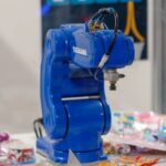 A robotic arm using advanced imaging technology to assemble components with precision on a production line.